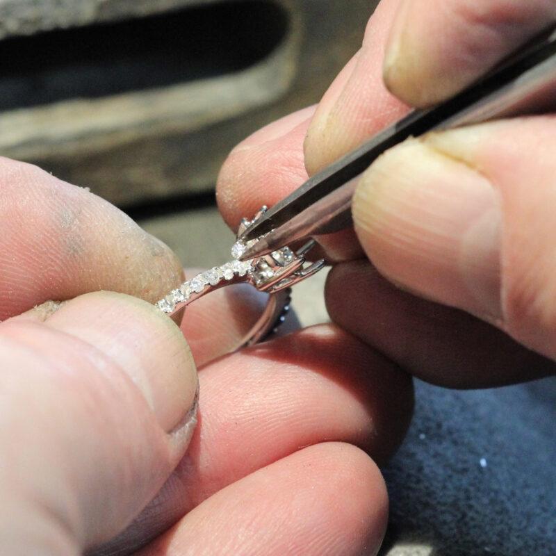 Engagement ring with a diamond pave band being set