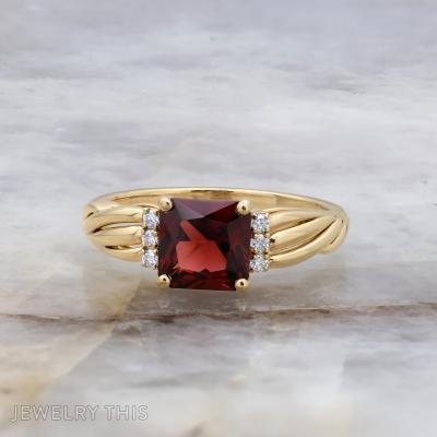 Custom engagement ring with radiant cut center stone, sculpted shoulders, and round accent stones.