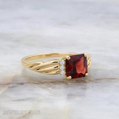 Custom engagement ring with radiant cut center stone, sculpted shoulders, and round accent stones.