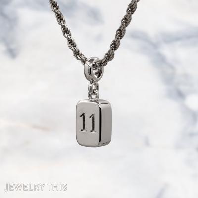 Three-dimensional silver charms shaped as a number block, roller skate, and construction cone.